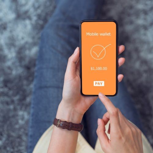 Hand holding a phone while making a mobile payment.